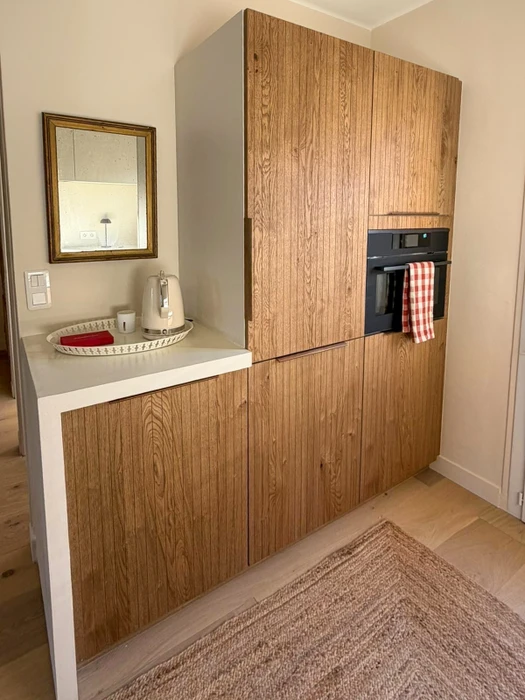 Intérieur d'un chalet en bois avec mezzanine, poutre apparente et conduit de poêle noir