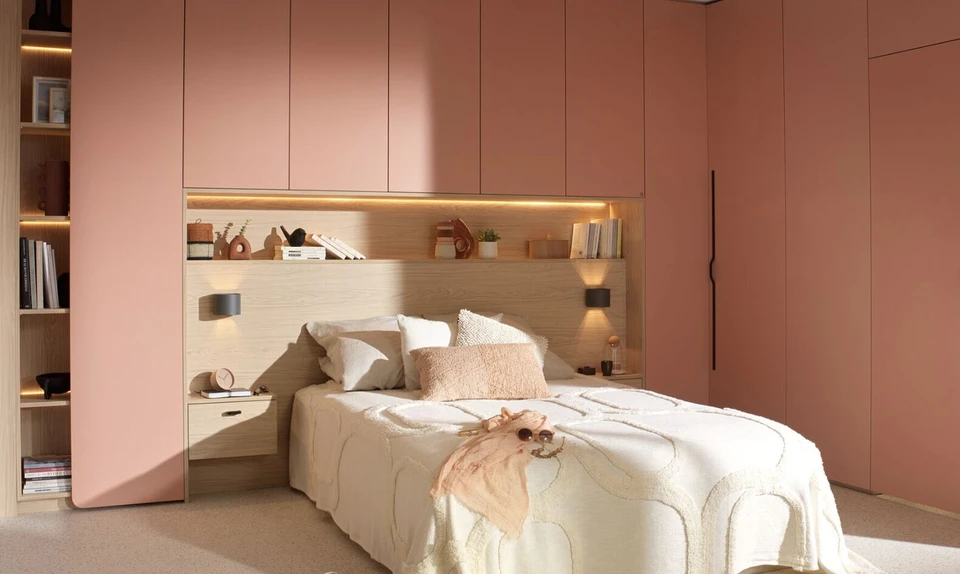 Dressing-room moderne avec système de rangement modulaire blanc, penderies organisées par couleurs vives (jaune, orange, rose), étagères compartimentées pour chaussures et accessoires, tiroirs intégrés